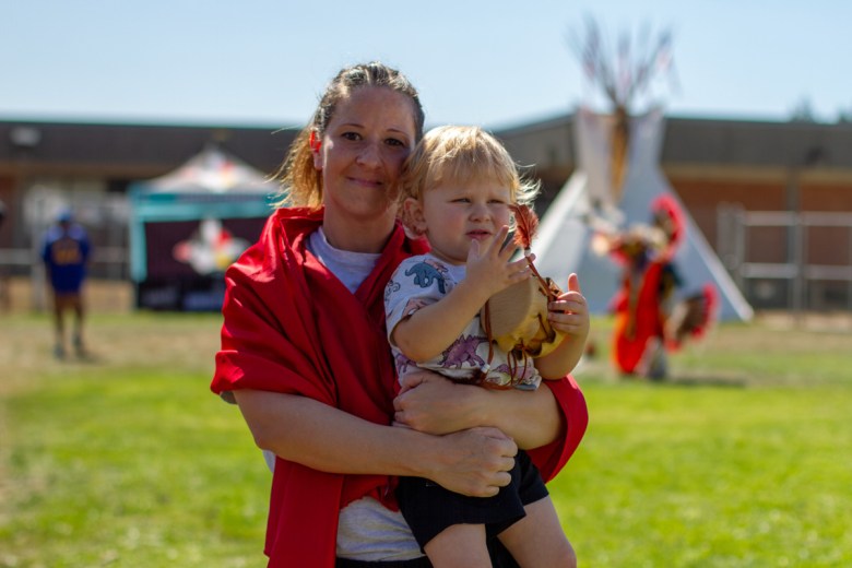 Beverly Baker (Colville and Iroquois) holds her 2-year-old son, Konnyr, as he plays with a drum she made him in the weeks leading up to the powwow at Washington Corrections Center for Women in Gig Harbor, Washington.