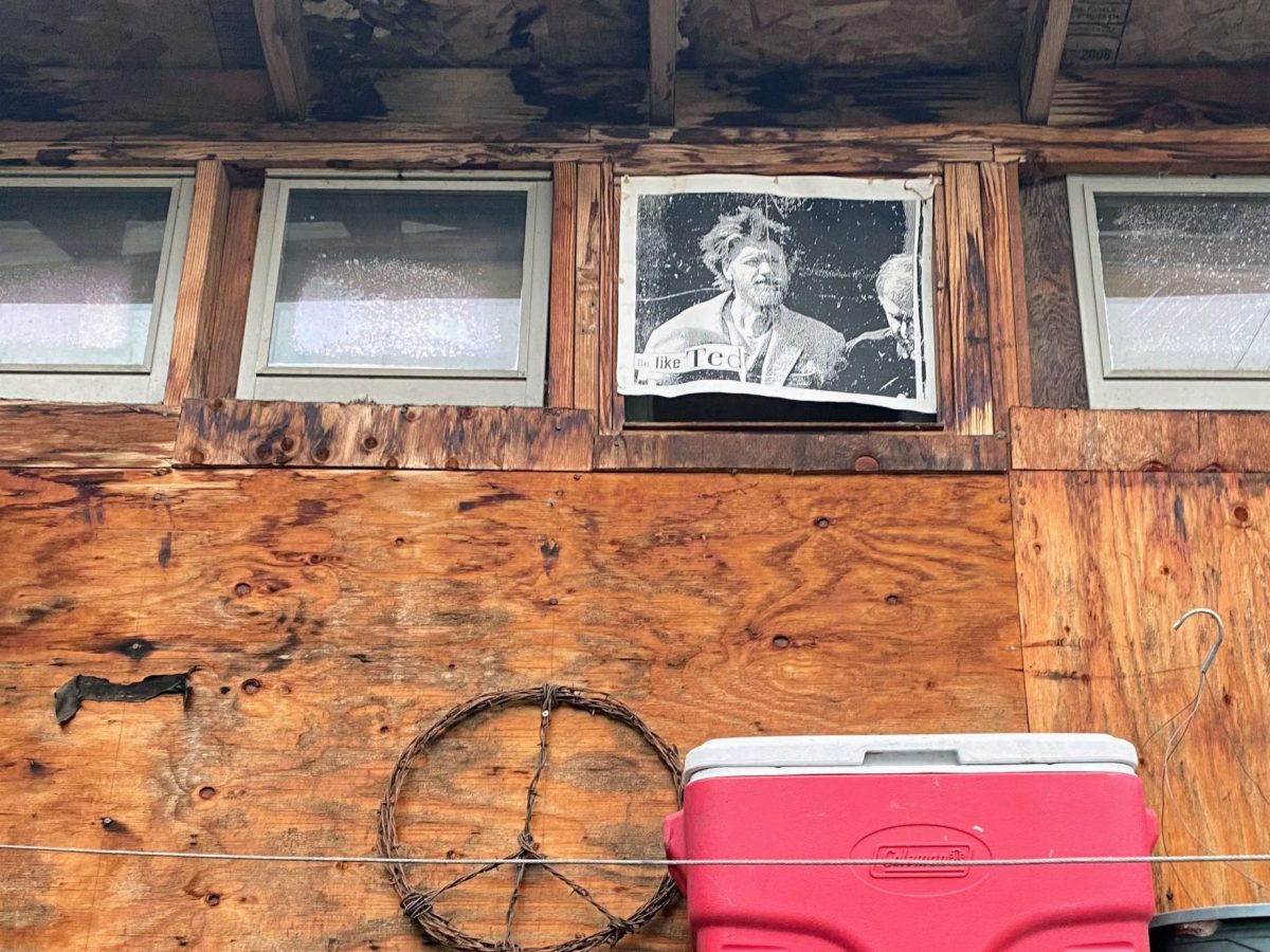 A photo of Ted Kaczynski positioned in the window of a member of the Eugene, Oregon activist community. It reads “Be Like Ted.”