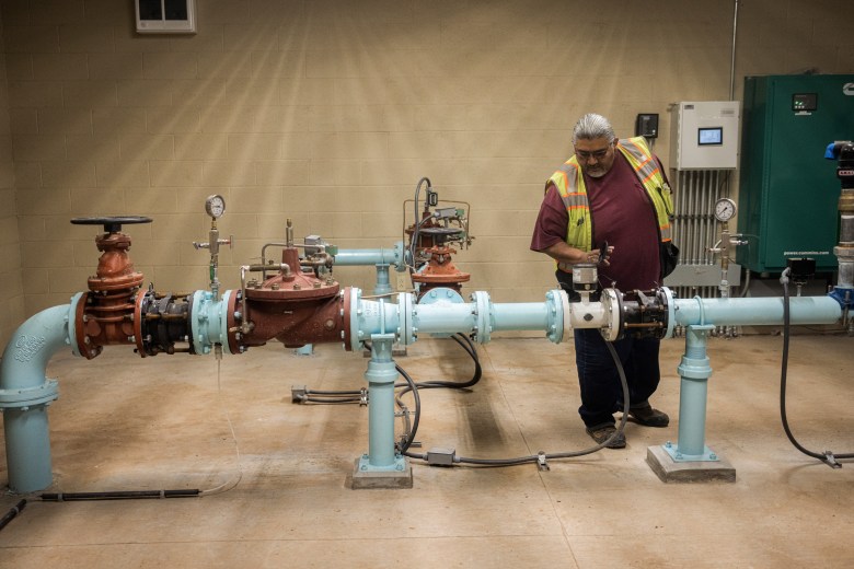 A worker examines equipment at one of the wells of the Hopi Arsenic Mitigation Project.