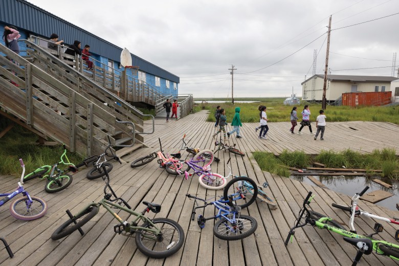 Children play basketball outside of Akiuk Memorial School. There are limited areas for kids to play in Akiuk because so much of the ground is saturated with water.